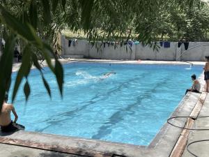 a group of people in a swimming pool at MUD ROOMS by MANOKUR- E- BASA in Minapin