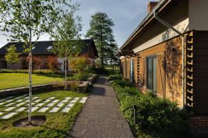 a path next to a house with a tree at Siedlisko Dańce 91 in Hanna