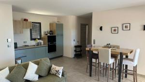 un salon et une cuisine avec un canapé et une table dans l'établissement Un air de paradis à Corbara, à Corbara