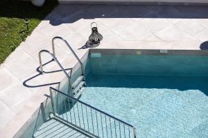 a bird sitting on the side of a swimming pool at Luxurious Villa Kirianna - Private Pool, Jacuzzi, Sauna, & Gym - 13km to Rethymno center in Kiriánna