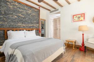 a bedroom with a bed and a brick wall at Hotel Unique-Boutique Class - Adults Only in Fethiye