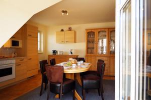 eine Küche mit Tisch und Stühlen in einem Zimmer in der Unterkunft Familienurlaub Natur- & Zentrumsnah im Granitzhof App 03 in Binz