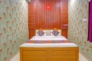 a bedroom with a bed with a wooden wall at FabExpress Yadhuvanshi Dhaam- 900m from Prem Mandir and Iskcon Temple in Vrindāvan