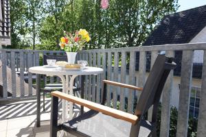ein Tisch mit einer Vase mit Blumen auf einem Balkon in der Unterkunft Familienurlaub Natur- & Zentrumsnah im Granitzhof App 03 in Binz