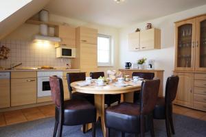 eine Küche mit Tisch und Stühlen in einem Zimmer in der Unterkunft Familienurlaub Natur- & Zentrumsnah im Granitzhof App 03 in Binz