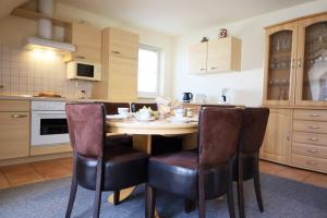 eine Küche mit einem Holztisch und Stühlen in der Unterkunft Familienurlaub Natur- & Zentrumsnah im Granitzhof App 03 in Binz + 12 Fotos