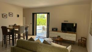 un salon avec un canapé, une télévision et une table dans l'établissement Un air de paradis à Corbara, à Corbara