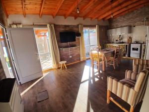 a kitchen and dining room with a table and chairs at La Casa de Oozu in Sierra de la Ventana