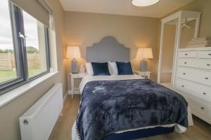 a bedroom with a large bed and two windows at Clarmes House in Limavady