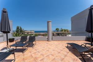 a patio with chairs and umbrellas on a roof at Kalamaki Del Mar in Chania