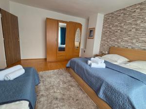 a bedroom with two beds and a brick wall at Apartmány 105 in Habovka