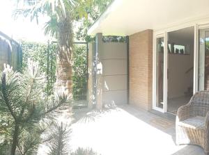 a patio with two chairs and a palm tree at Studio Waterland in Ooltgensplaat +17 photos