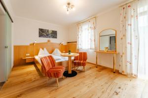 una camera d'albergo con un letto, un tavolo e delle sedie di Glautschhof a Weissensee