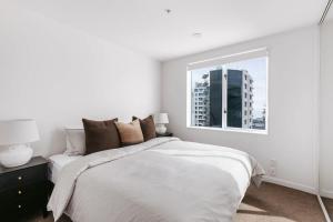 une chambre blanche avec un lit et une fenêtre dans l'établissement Luxe Mount Escape Stunning Sea Views Pool & Gym, à Mount Maunganui 30 autres photos