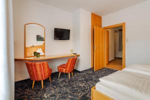 una camera d'albergo con scrivania e 2 sedie di Glautschhof a Weissensee