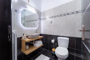 a bathroom with a toilet and a sink and a mirror at Kalamaki Del Mar in Chania