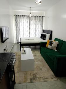 a living room with a green couch and a table at Heavenly Castles in Ongata Rongai 