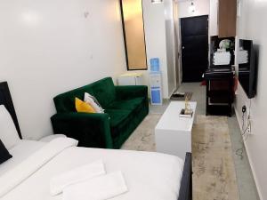 a living room with a green couch and a green chair at Heavenly Castles in Ongata Rongai 