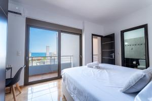 a bedroom with a bed and a view of the ocean at Kalamaki Del Mar in Chania