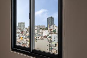a window with a view of a city at SAZI RESIN HOTEL - Free Nails HairWash in Ho Chi Minh City