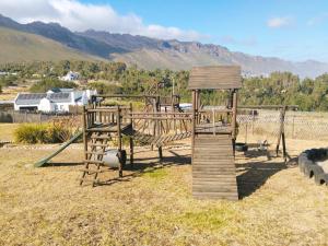 a wooden playground with a slide and some sheep at Into the Sunset Manor in Gordonʼs Bay +4 photos