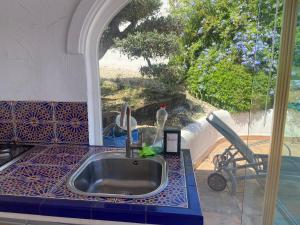 un comptoir de cuisine avec un évier et une fenêtre dans l'établissement Jávea Villa entière piscine et cuisine d'été à pinosol, à Jávea