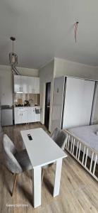 a living room with a white table and a bed at ilios in Kobuleti