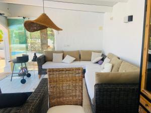 - un salon avec un canapé et des fauteuils en osier dans l'établissement Jávea Villa entière piscine et cuisine d'été à pinosol, à Jávea