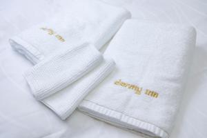 丰桥市Dormy Inn Express Toyohashi的两条白毛巾上写着“健康热身” 更多37张照片