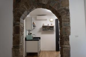 ein Torbogen, der in eine Küche mit Kühlschrank führt in der Unterkunft Alba apartments in Biassa
