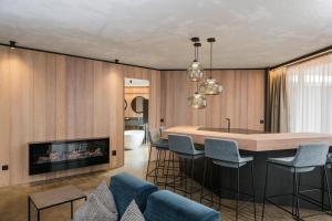 a living room with a table and a fireplace at Lindenhof Pure Luxury & Spa DolceVita Resort in Naturno