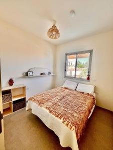 a bedroom with a bed and a window at House in the village in Kfar Yehezkel