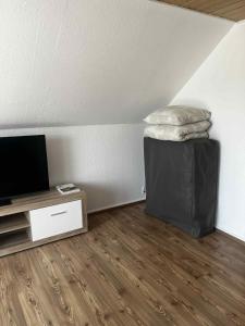 a room with a tv and a table with a pillow at Holiday Nest 2 in Sønderborg