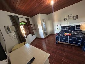 Un dormitorio con una cama y una mesa en una habitación. en Pousada Marina bonita Rasa, en Búzios