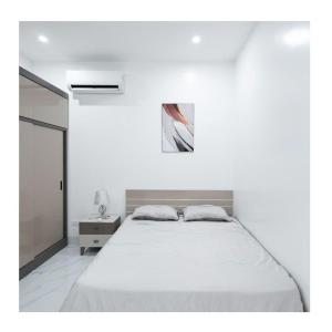 una camera bianca con un letto e una foto appesa al muro di Giảm Giá 25 Phần Trăm- Homestay - Kim Mã - Giang Văn Minh a Hanoi