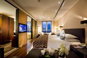 ein Hotelzimmer mit einem großen Bett und einem TV in der Unterkunft SSAW Boutique Hotel Hefei Intime Centre in Hefei