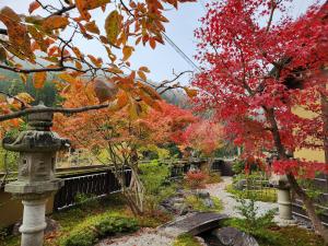 a garden in autumn with a stone lantern and a tree at Miyama Resort Kayabuki-tei - Matsuba's Inn in Nantan city