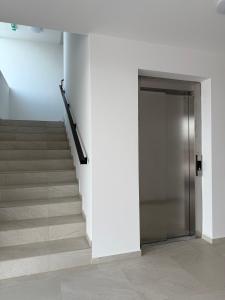 un escalier avec une porte et des marches en métal dans l'établissement Luxapartments Studio 305 Penati Golf Resort, à Šajdíkove Humence