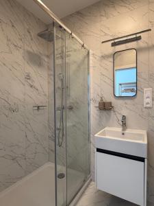 une salle de bain avec douche et lavabo dans l'établissement Luxapartments Studio 305 Penati Golf Resort, à Šajdíkove Humence