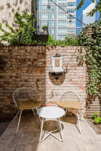 two chairs and a table in front of a brick wall at Private Beautiful Townhome w Zen Garden in New York +21 photos