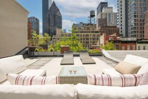 a rooftop patio with white furniture and a city skyline at Private Beautiful Townhome w Zen Garden in New York