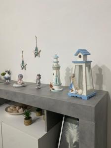 a shelf with a toy lighthouse and figurines on it at Due passi dal mare in Livorno