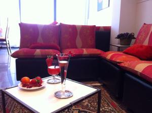 a living room with a couch and a table with two glasses at Hotel Aurora in Gabicce Mare
