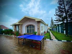 una mesa de ping pong azul frente a una casa en Serene 3BR Retreat with Lush private Garden, mini gym and spa access, en Abeokuta