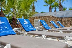 a row of chaise lounge chairs on a beach at Karmnu Holiday Farmhouse in Għasri