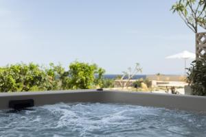 a bath tub filled with water with trees in the background at Cavo Marelia in Amoopi