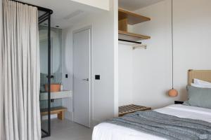 a bedroom with a bed and a glass closet at Cavo Marelia in Amoopi