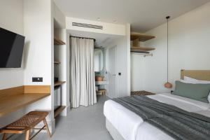 a bedroom with a bed and a flat screen tv at Cavo Marelia in Amoopi
