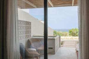 a room with a balcony with chairs and a desk at Cavo Marelia in Amoopi