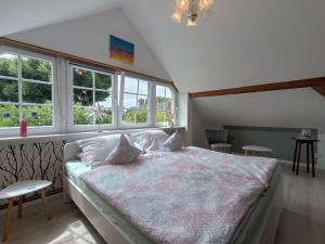 a bedroom with a large bed with windows at Ferienwohnung Hinz - Gemütliche Unterkunft für 2 Personen mit modernem Bad in Ellingstedt +20 photos